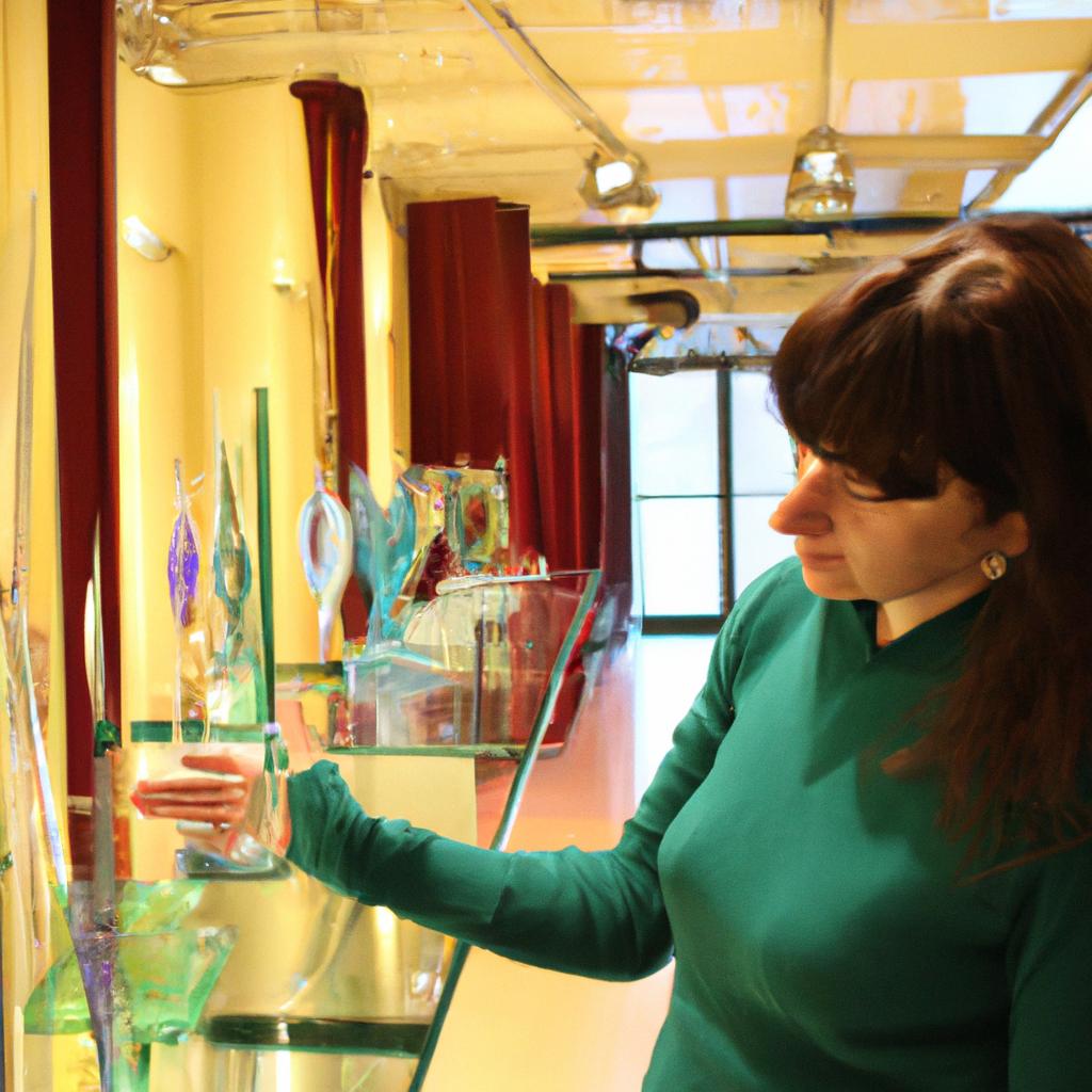 Person examining various glass artworks